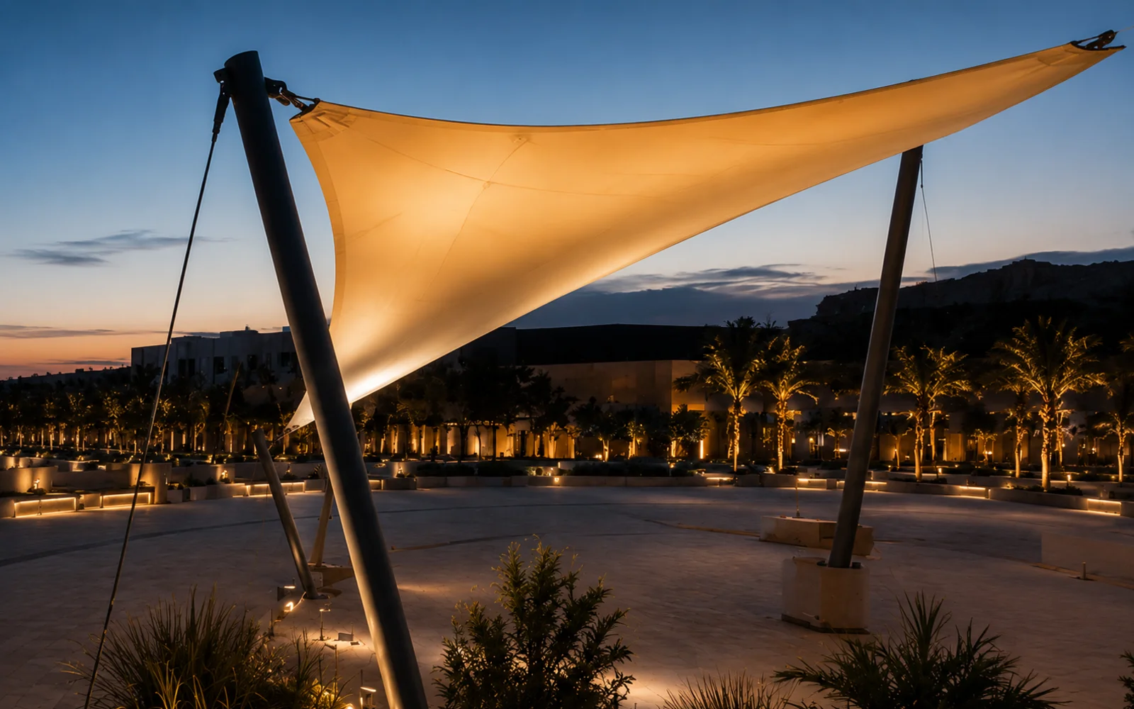 Aluminium pergola and tensioned shade sails over an outdoor public seating area in daylight